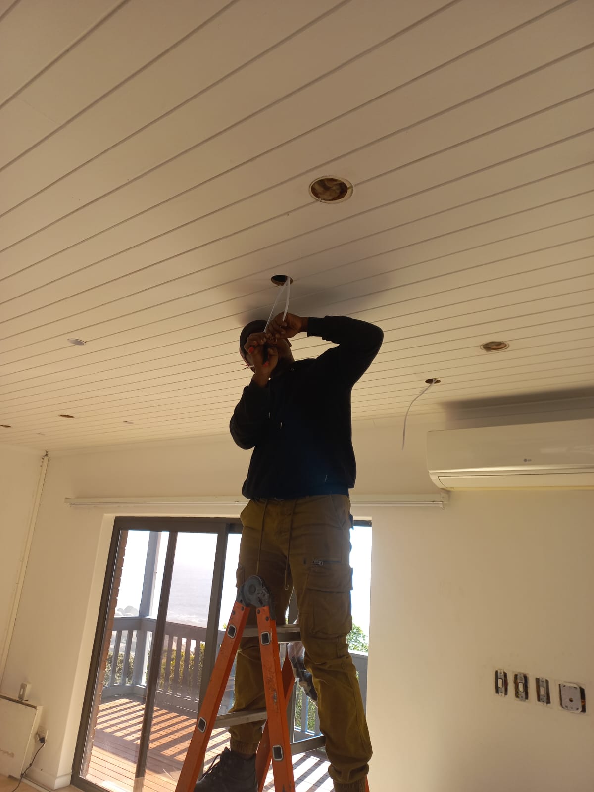 Air Tech Solution Systems electrician installing recessed downlights on site